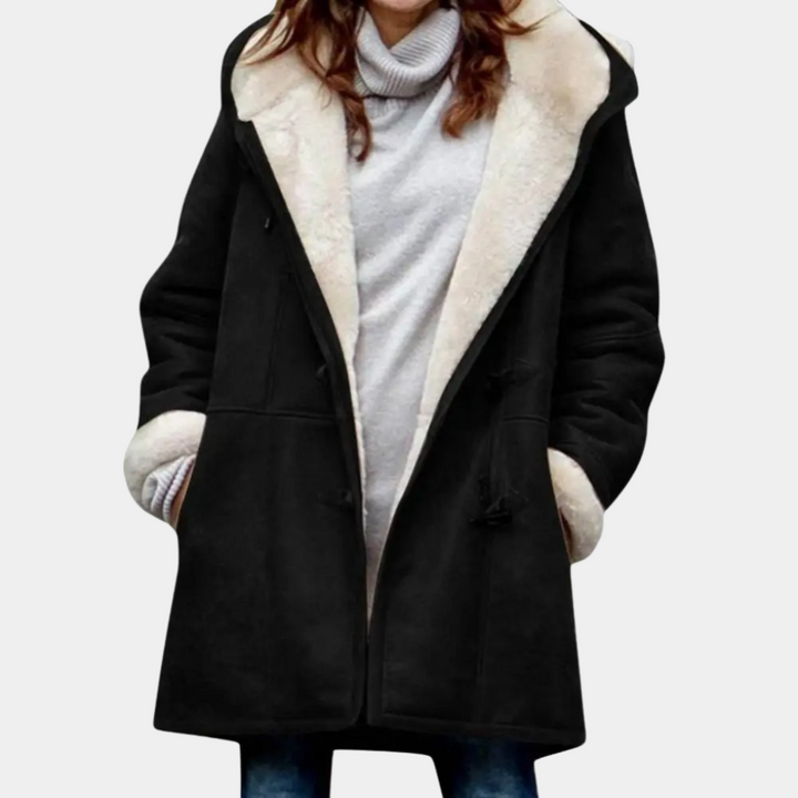Lange zwarte dames winterjas met witte voering, capuchon en knoopsluiting. Stijlvolle en warme jas voor koude seizoenen.